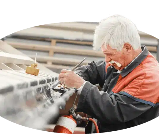 An older handwerker working on a metal roof.