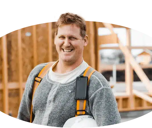 Ein Handwerker lächelt auf einer Baustelle.
