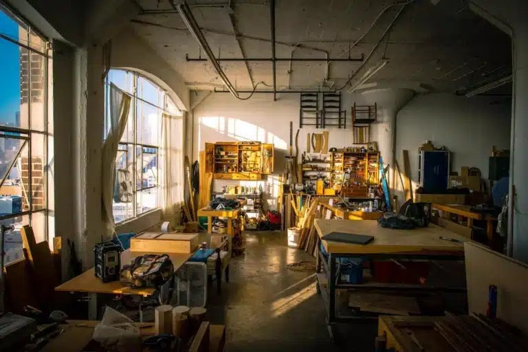 A woodworker's workspace equipped with various tools and a window providing ample natural light.