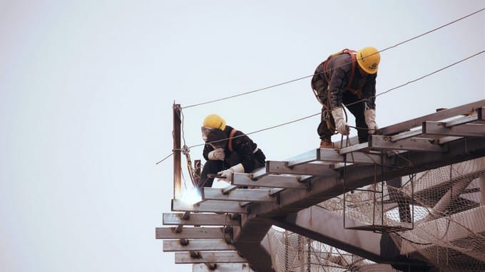 Zwei Bauarbeiter arbeiten an einer Treppe.